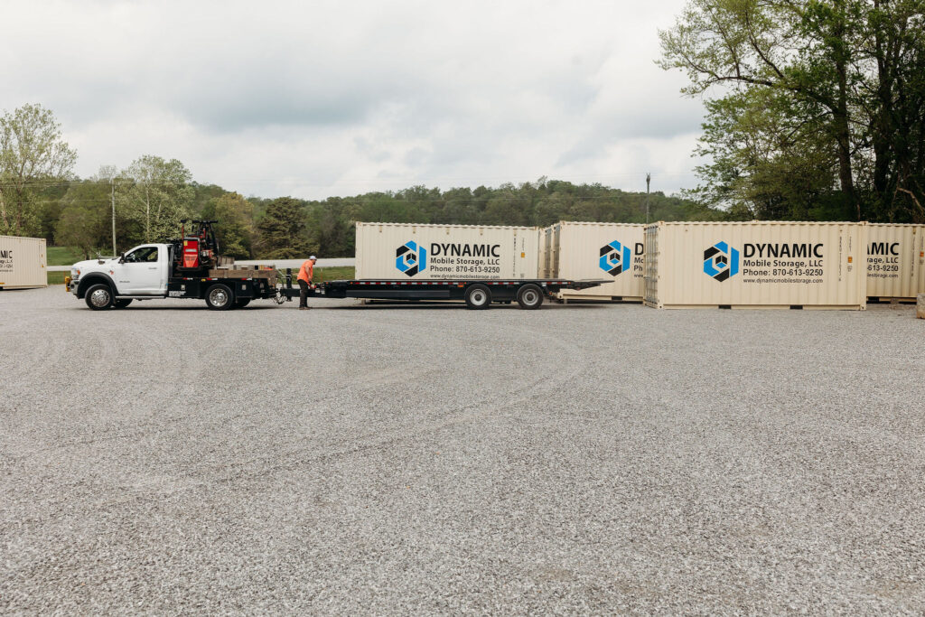A shipping container (portable storage) being loaded onto a truck