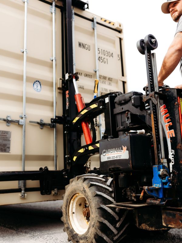A man connecting moving machine to a shipping container